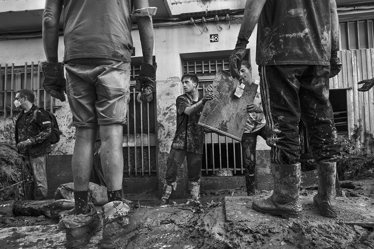 Volunteers clearing mud and debris from the streets of Paiporta after the 2024 Valencia DANA flood