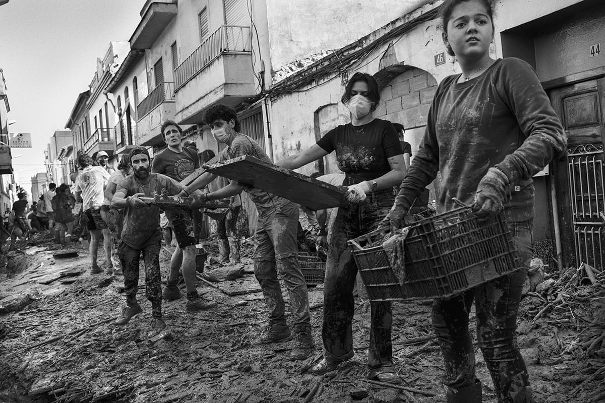 Human chain of volunteers clearing debris and mud from the streets of Paiporta after the 2024 DANA flood