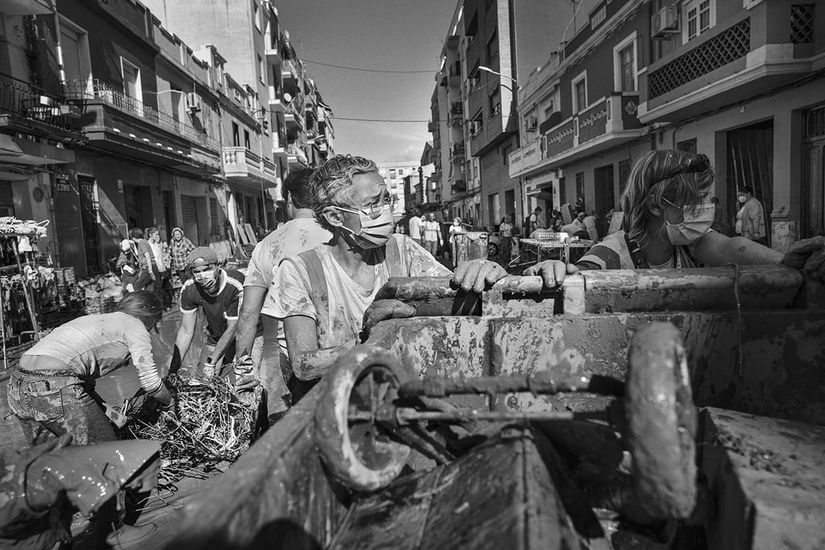 Female volunteer helping with cleanup and debris removal in the streets of Torrent after the Valencia DANA