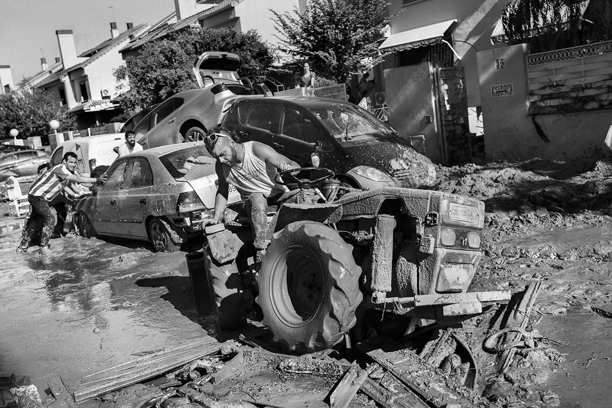 Resident of Paiporta using a tractor to dig a car out of the mud after the Valencia DANA flood