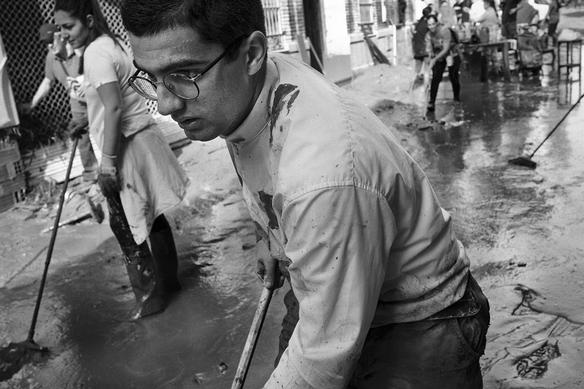Priest of the Iglesia de la Inmaculada helping clear mud from the streets of Paiporta after the DANA