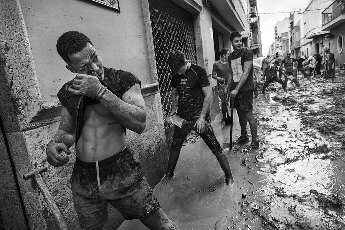 Volunteers shovelling mud and debris from the streets of Paiporta after the 2024 Valencia DANA flood
