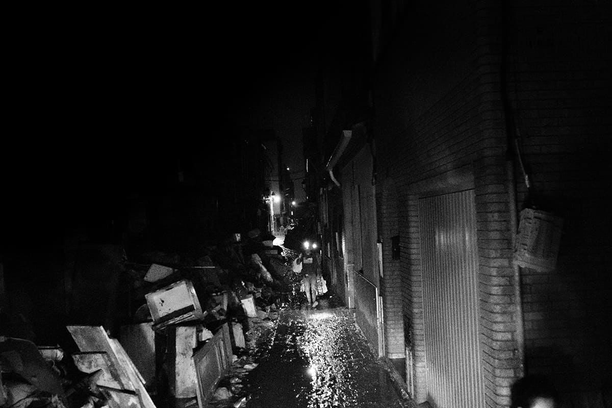 Residents of Paiporta walking through dark devastated streets at night after the 2024 Valencia DANA flood