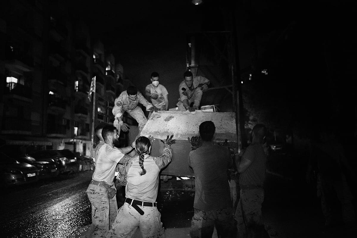 Spanish Army soldiers loading debris in the streets of Paiporta at night after the 2024 Valencia DANA flood