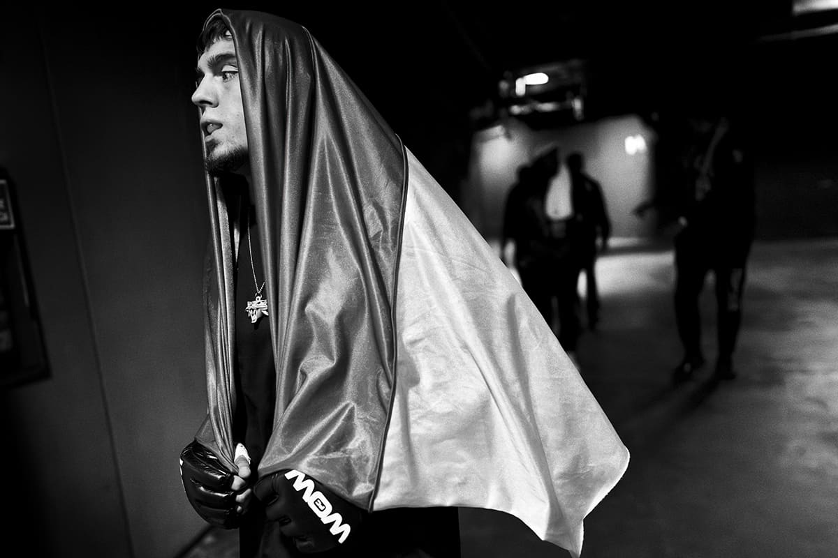 Artur Hrynchak walks draped in a Ukrainian flag before an MMA fight at WOW FC in Madrid.