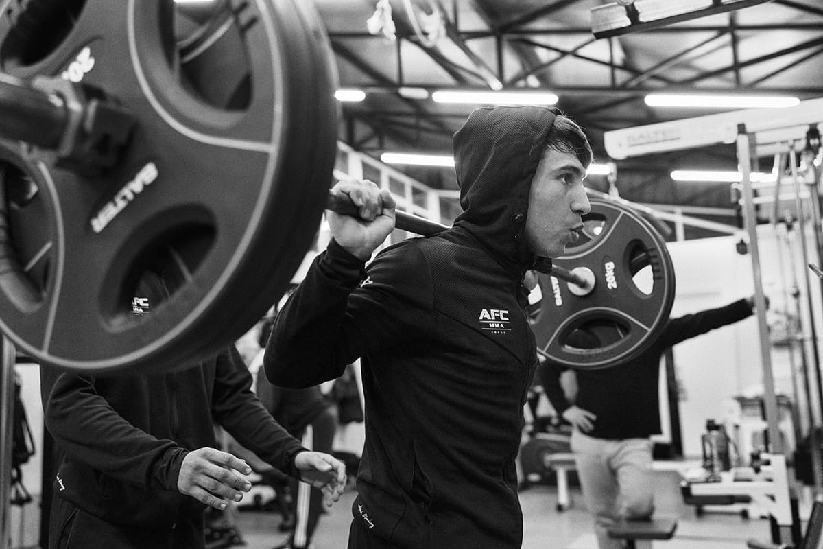 Diego Esteche performs strength training at AFC Villalba gym during an MMA workout in Madrid.