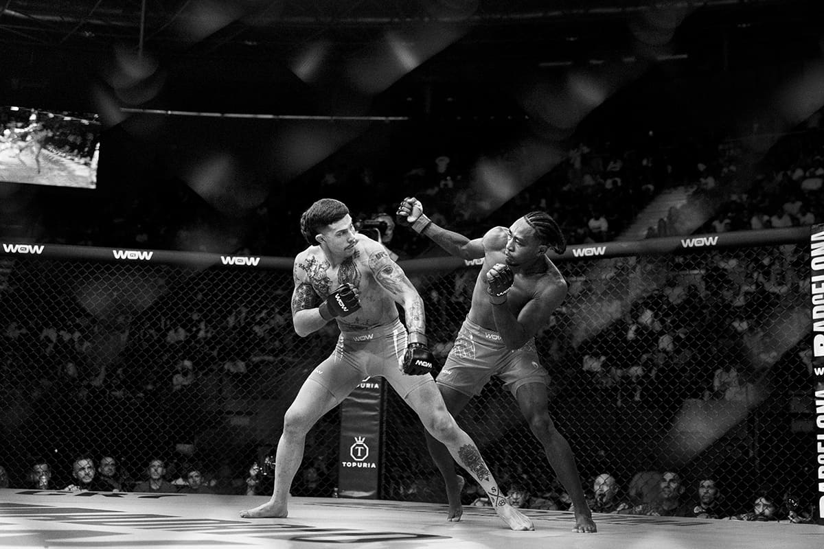 Brian Hooi and Miguel Angel Lozano exchange strikes during a lightweight title MMA fight at WOW 27 in Madrid.