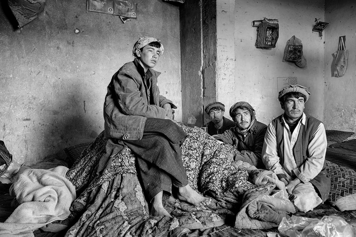 Afghan men gathered in a mud-walled room in the old market of Kabul, February 2009