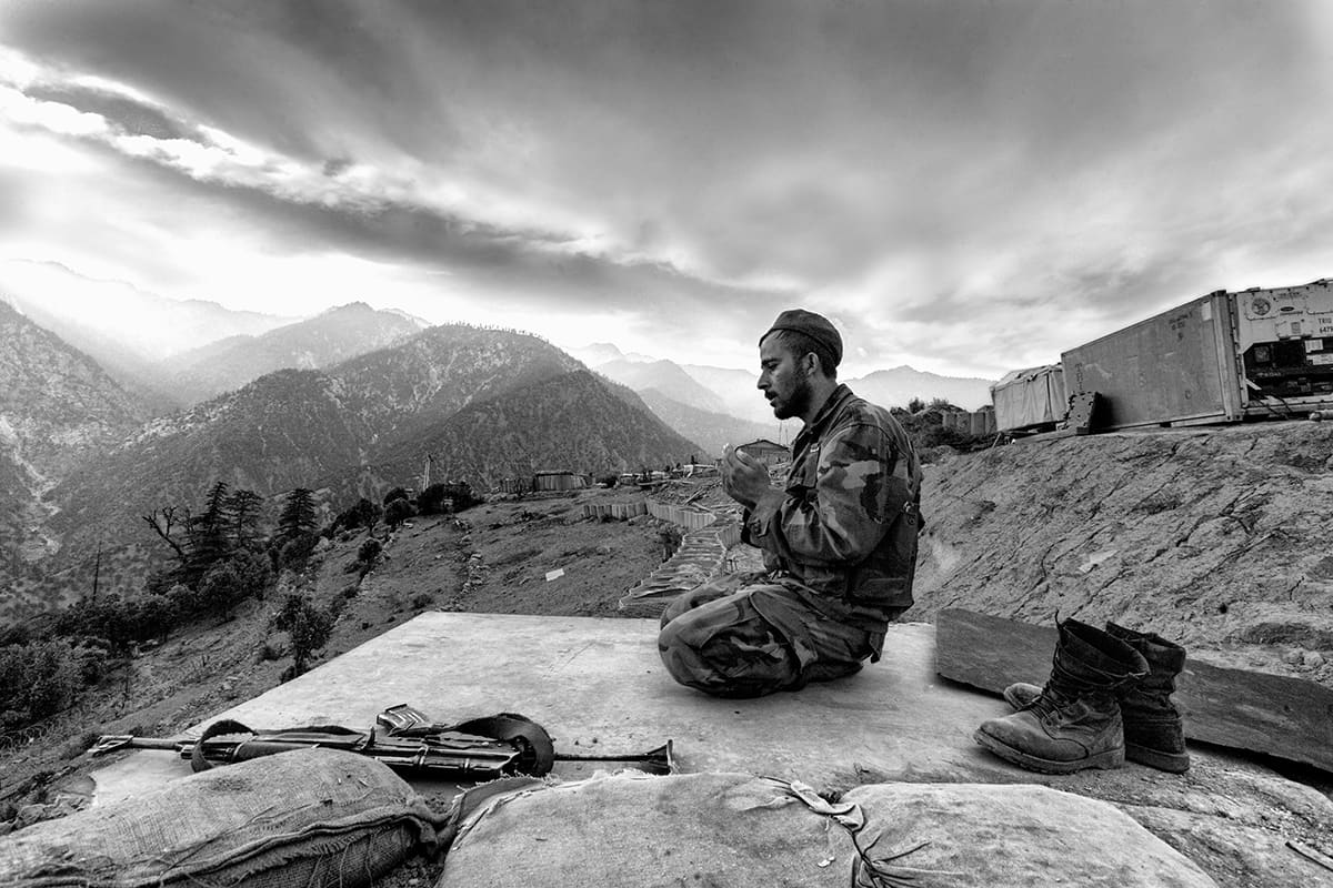 Afghan National Army soldier Nehmat prays at sunset on guard duty at Gowardesh Outpost near the Pakistani border, Nuristan, May 2007