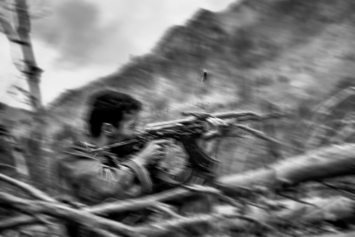 Afghan National Army soldier returns fire during an ambush near the Urstan Pass on the Afghanistan–Pakistan border, May 2007