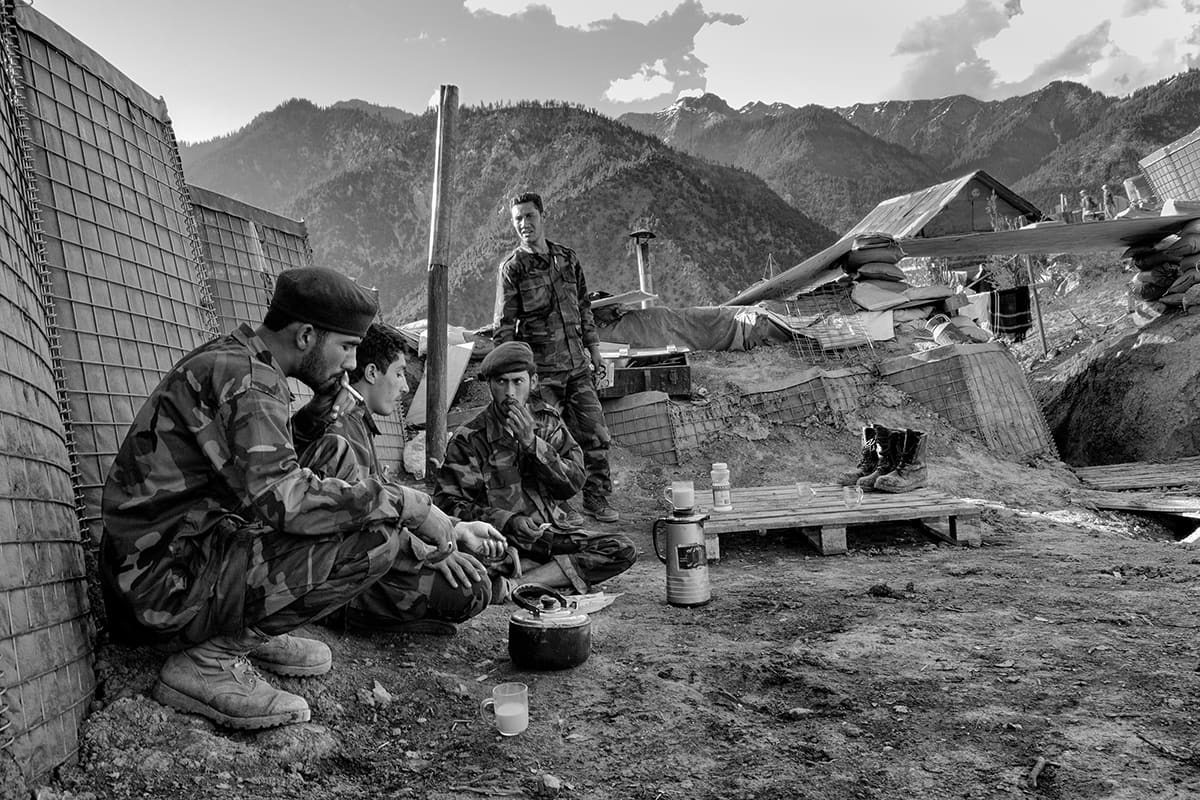 Afghan National Army soldiers rest with tea at Gowardesh Outpost in the mountains of Nuristan near the Pakistani border, May 2007