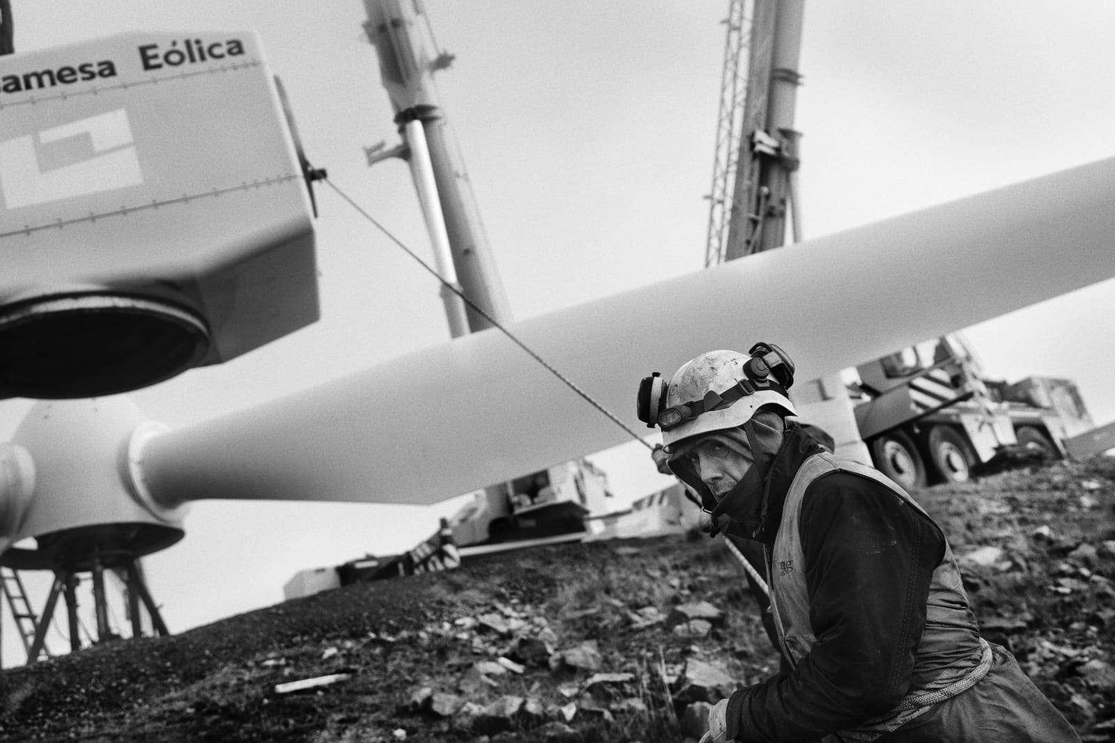Worker guiding a wind turbine rotor with a rope during assembly in Aldeavieja, Ávila, Spain, 2024