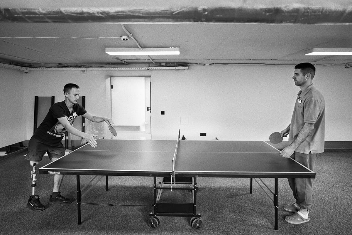 Alexander plays table tennis against his therapist inside the Superheroes hospital in Lviv.