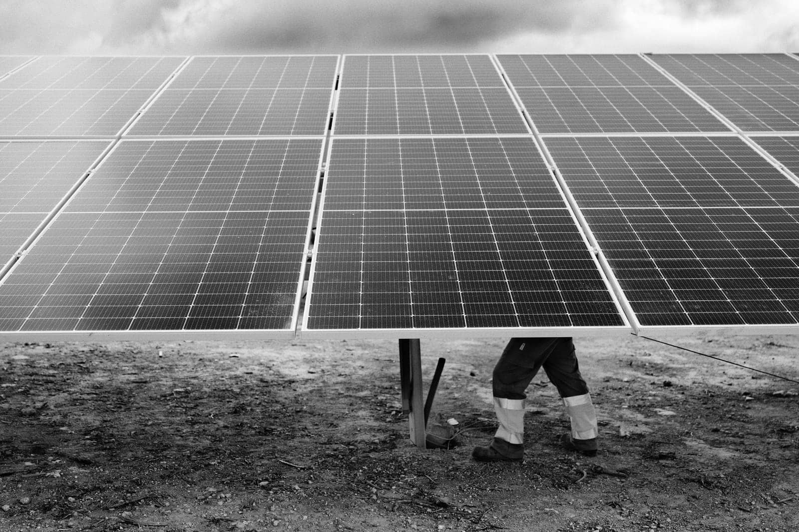 Worker among rows of photovoltaic panels at a solar plant in Andorra, Teruel, Spain, 2023