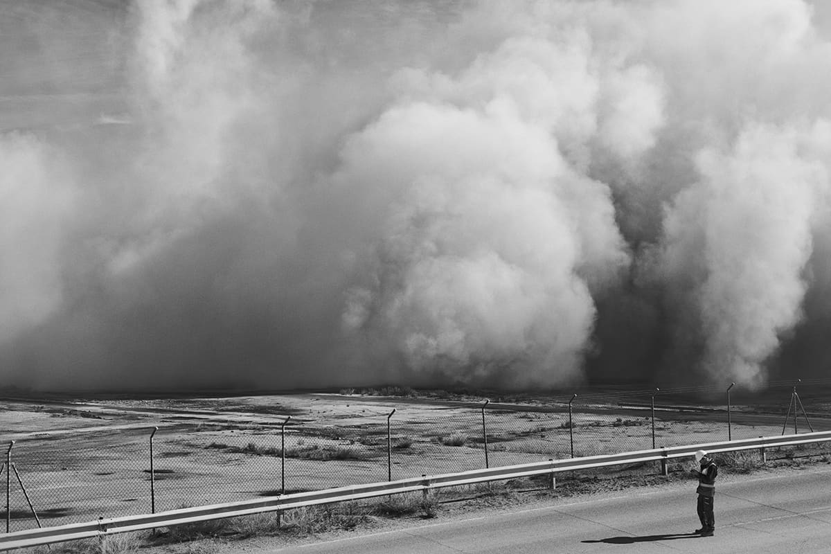 Cloud of dust spreading across the plain after the controlled demolition of the Andorra power plant chimney, Teruel, Spain, 2023