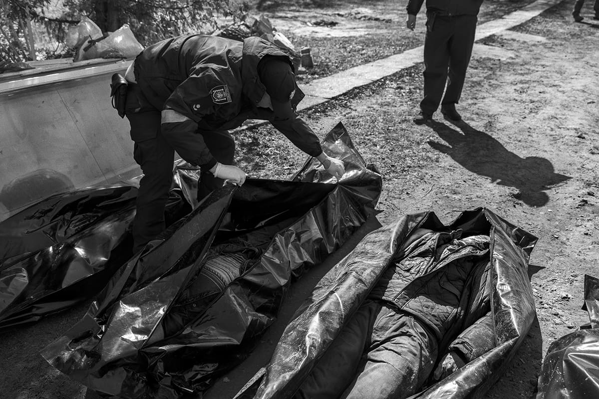 Police search the clothes of executed civilians in Bucha in an attempt to identify the bodies.