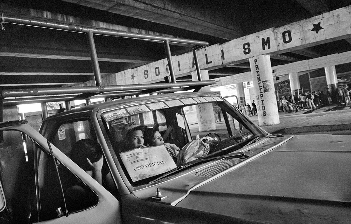 Chávez supporters wait inside an official vehicle during a government goods-for-food exchange
