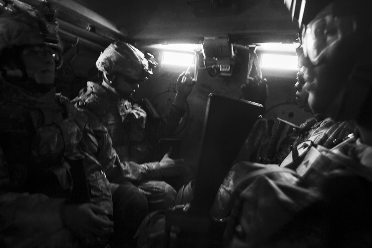 Members of Bravo Company, 2nd Platoon, 1st Cavalry Division ride inside an armored vehicle on their way to a joint house-search operation with Iraqi police in Karrada, Baghdad — part of the wider campaign that included the Fallujah battle Iraq