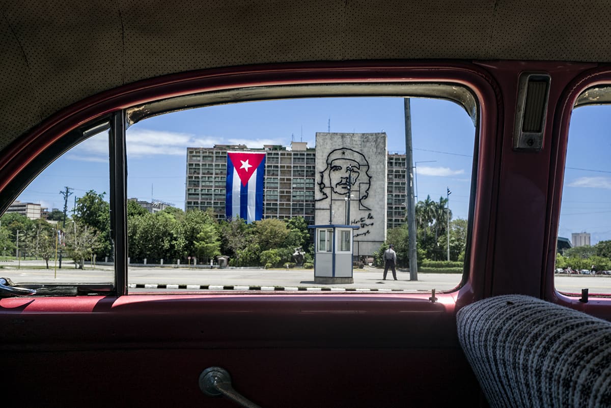 The Plaza of the Revolution in Havana seen through the window of a classic car, with the mural of Che Guevara.