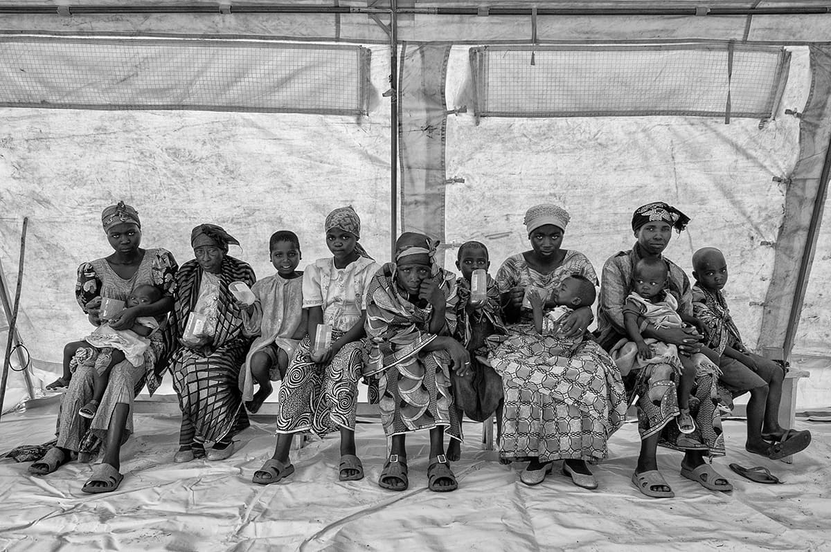 Women and children waiting on a bench in the cholera field hospital of the Kibati refugee camp.