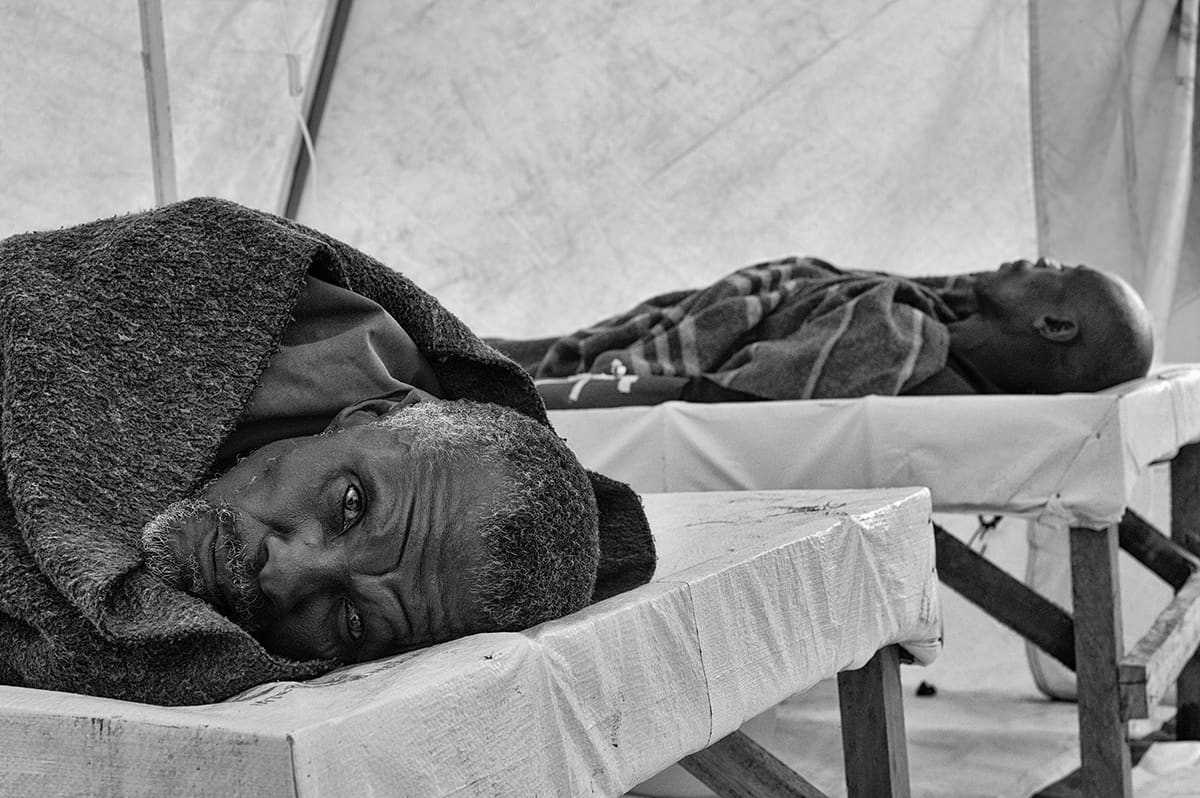 Two cholera patients lying on stretchers inside the field hospital of the Kibati refugee camp.