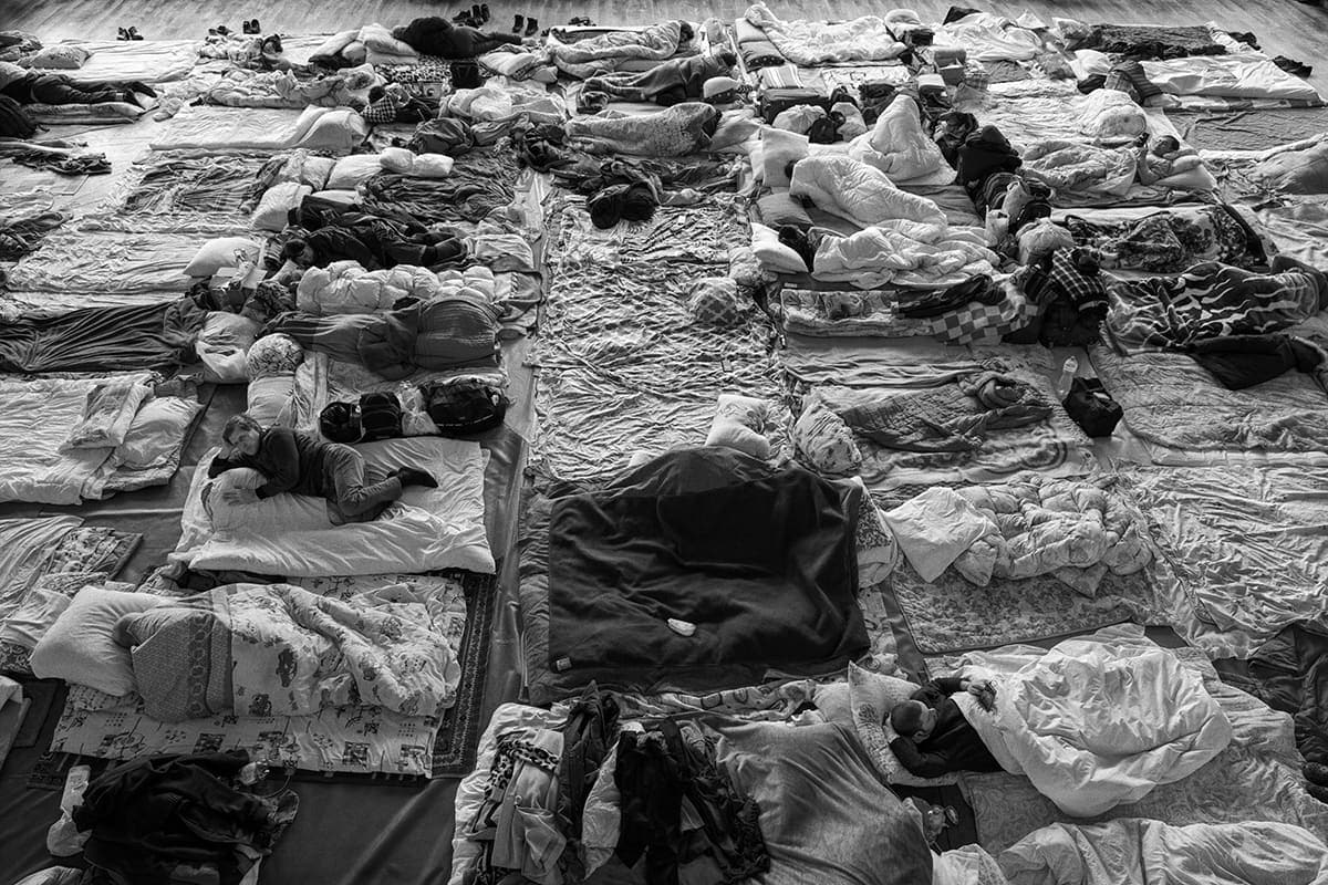 Internally displaced people take temporary shelter in the sports hall of the university's medical faculty in Lviv.