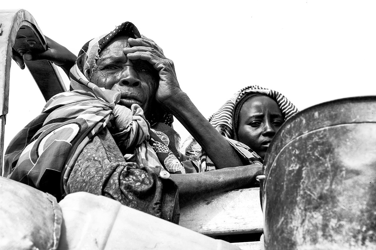 Elderly woman and a child on a truck during a displacement movement in Darfur, Sudan.