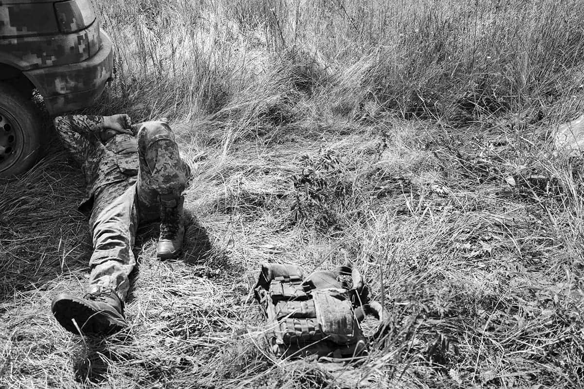 A soldier of the 80th Brigade rests, exhausted, after coming off the front line in Bakhmut.