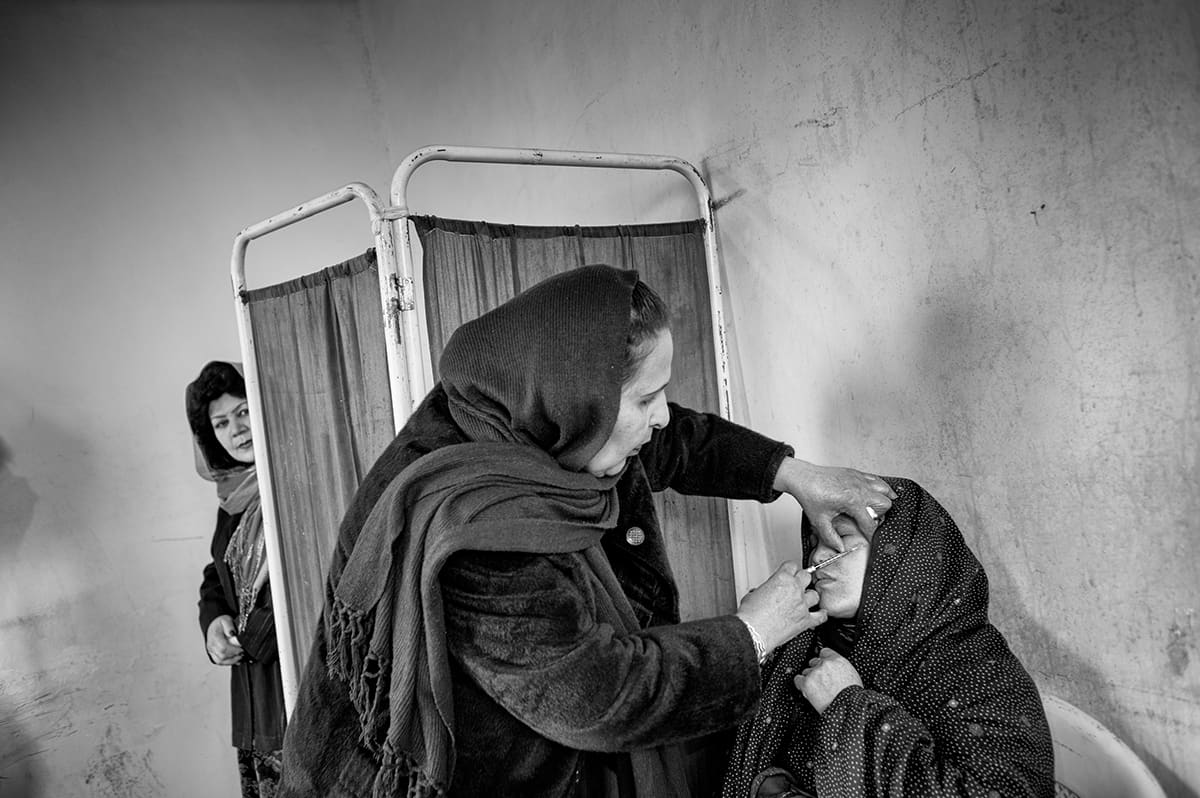 Afghan female doctor examining a patient at the Institute for Malaria and Leishmaniasis in Kabul, February 2009