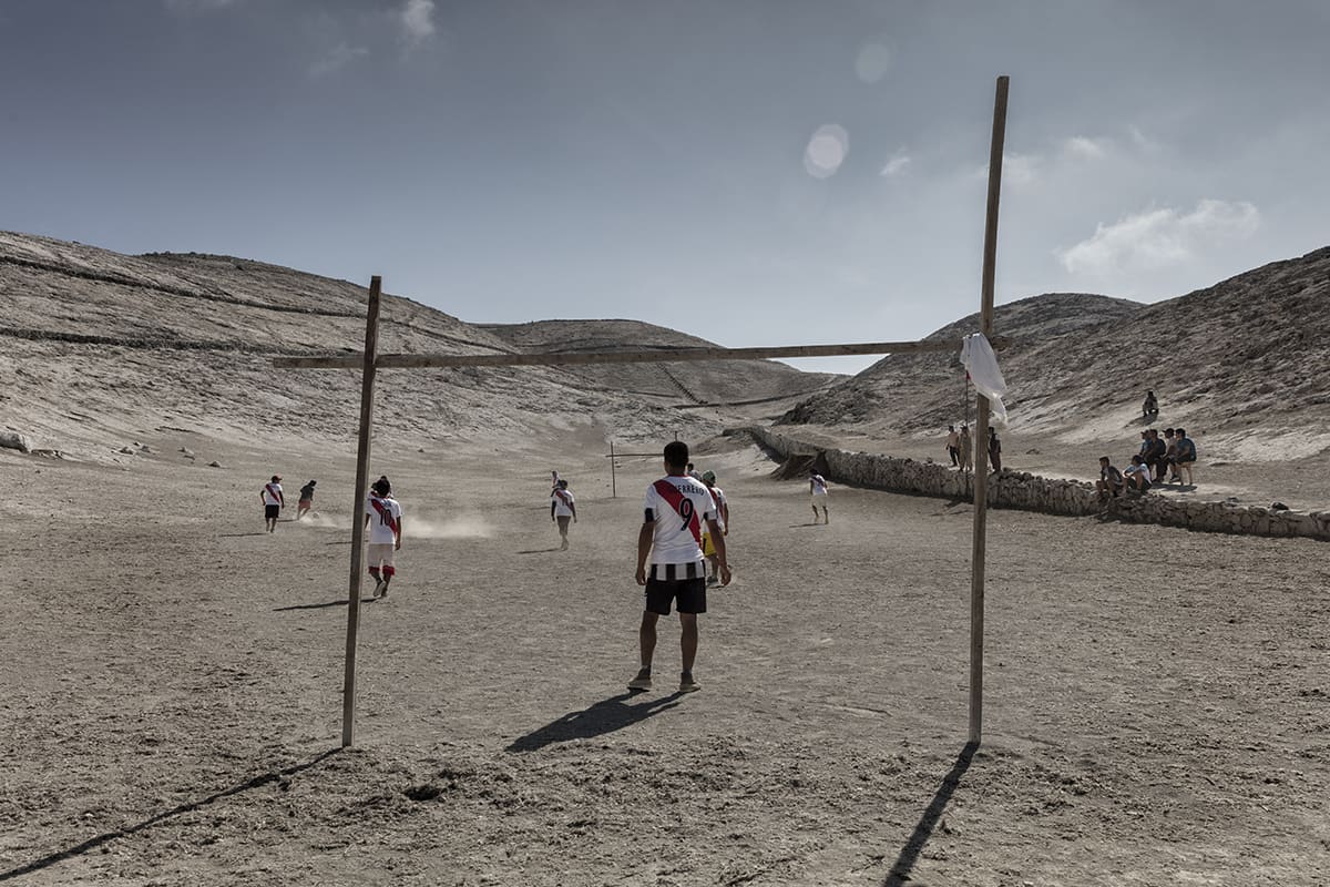 Football game between improvised wooden goalposts on the guano island of Asia, Peru.
