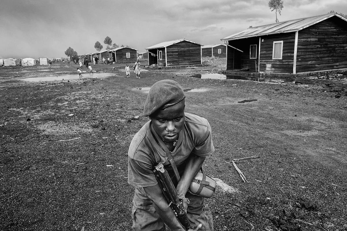 A Congolese army soldier crouching with his rifle at the frontline in Kibati, North Kivu.