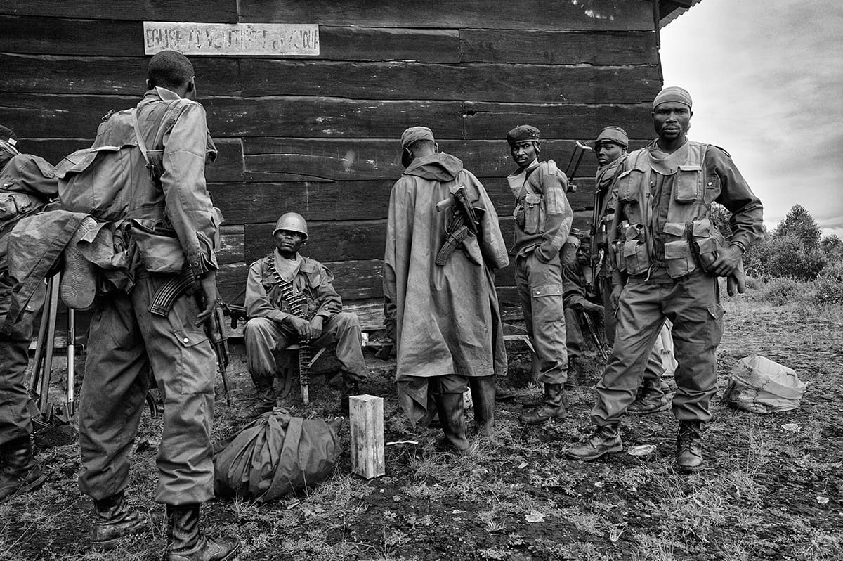 Congolese army soldiers gathered outside a wooden building at the frontline in Kibati.