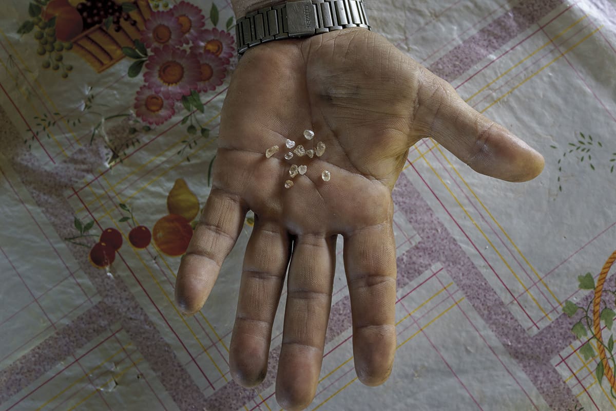 Hand of a garimpeiro showing small extracted diamonds