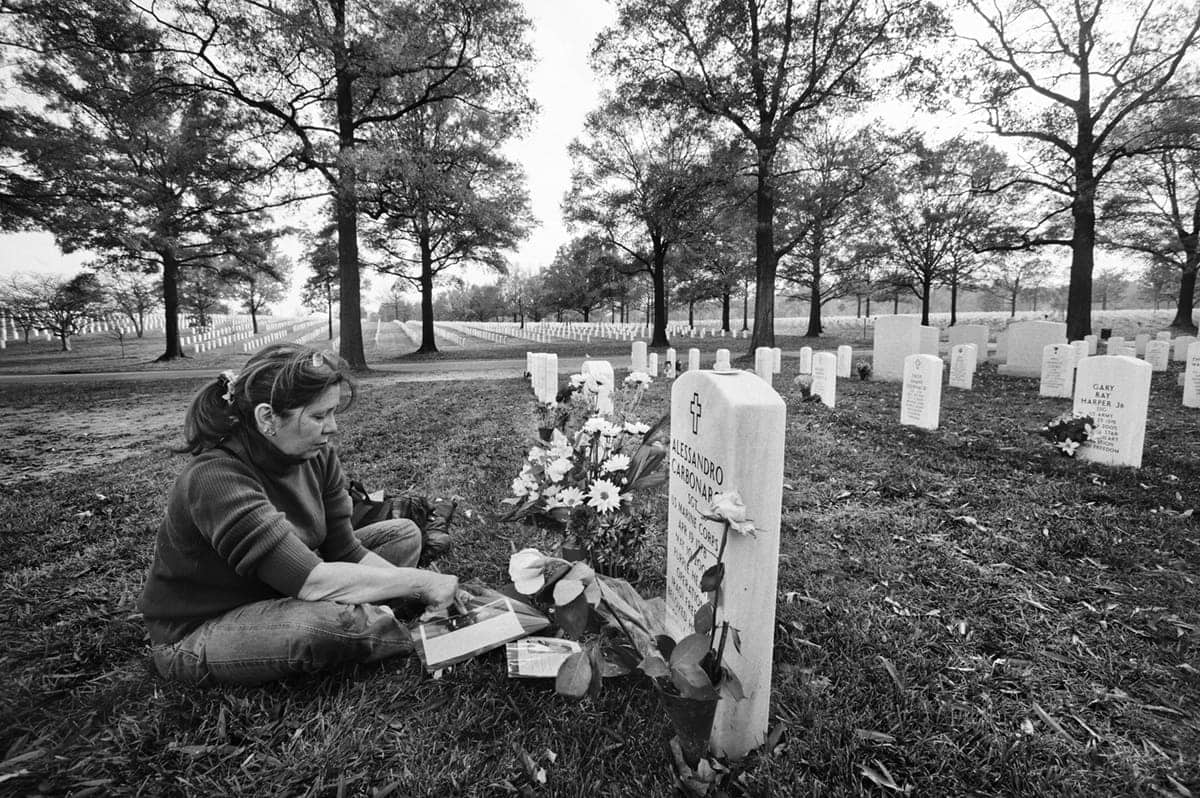 Gilda Carbonaro sits beside the grave of her son, a US Marine killed by an IED in the Fallujah battle Iraq, at Arlington National Cemetery