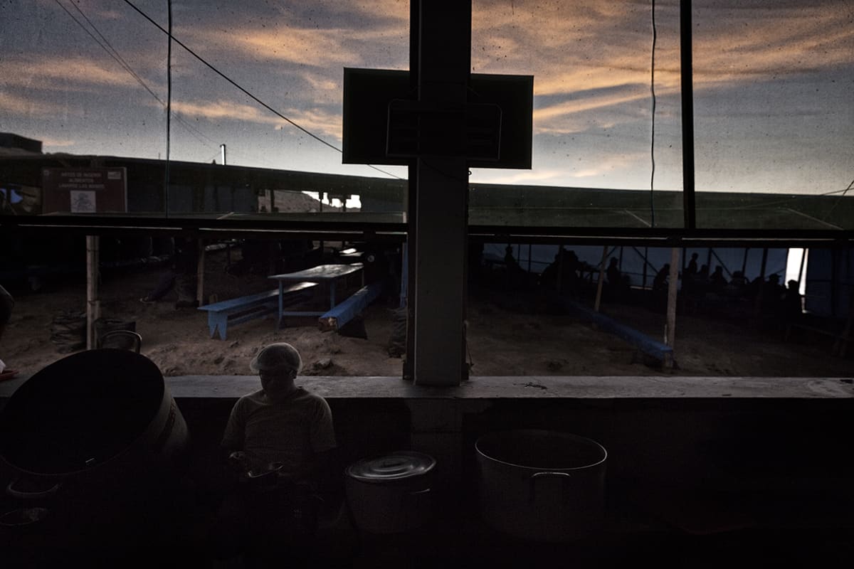 Guano worker eating his dinner at sunset in the island kitchen on Isla Asia, Peru.
