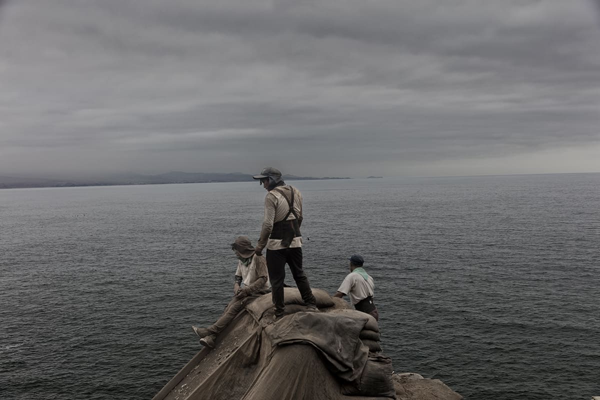 Guano workers taking a break on a structure overlooking the Pacific on Isla Asia, Peru.