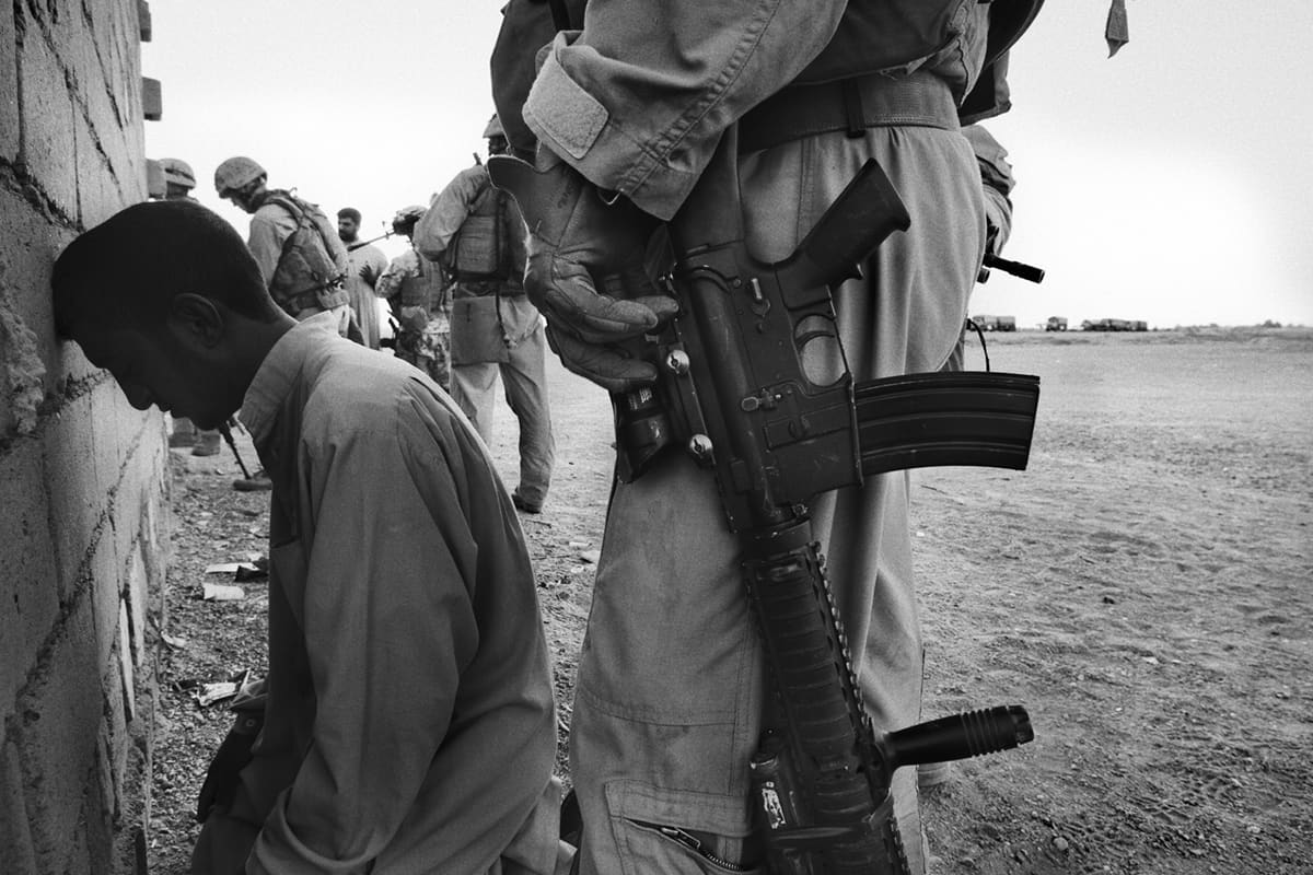 An Iraqi man is searched against a wall by US Marines from Bravo Company after being detained on suspicion of assisting insurgents in Fallujah