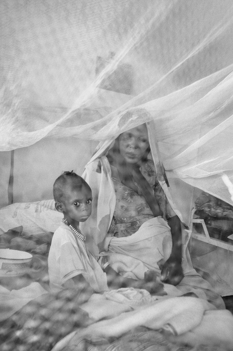Malnourished child and his mother under a mosquito net at a therapeutic feeding centre in Darfur.