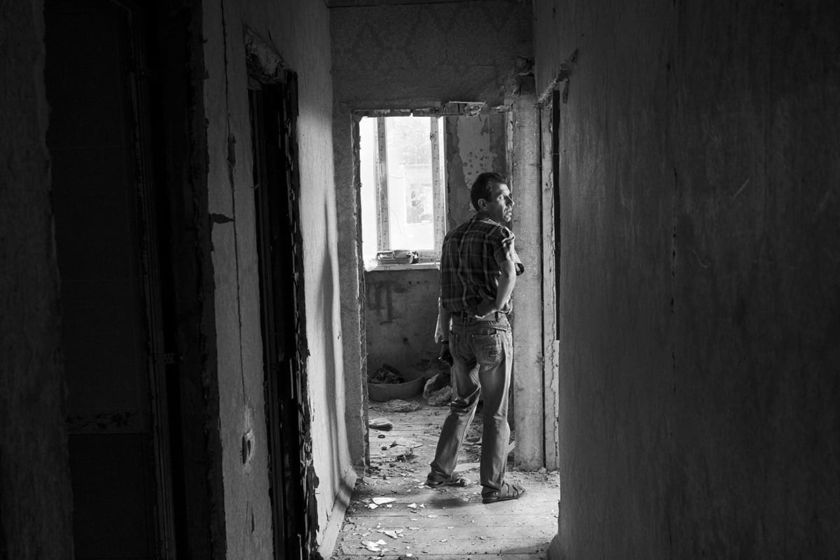 A civilian inspects the damage to his house in Sloviansk after the fighting.