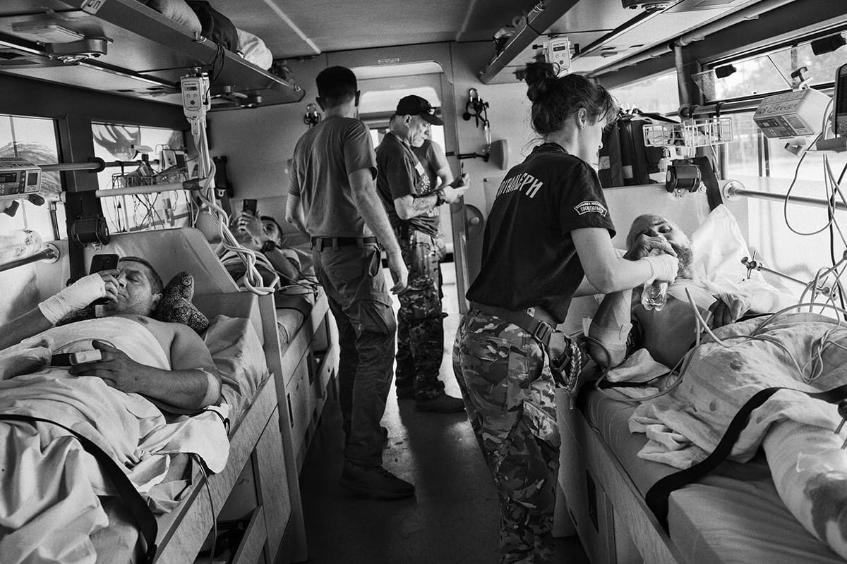 A doctor of the hospital bus evacuation unit treats a Ukrainian soldier wounded on the Pisky front.
