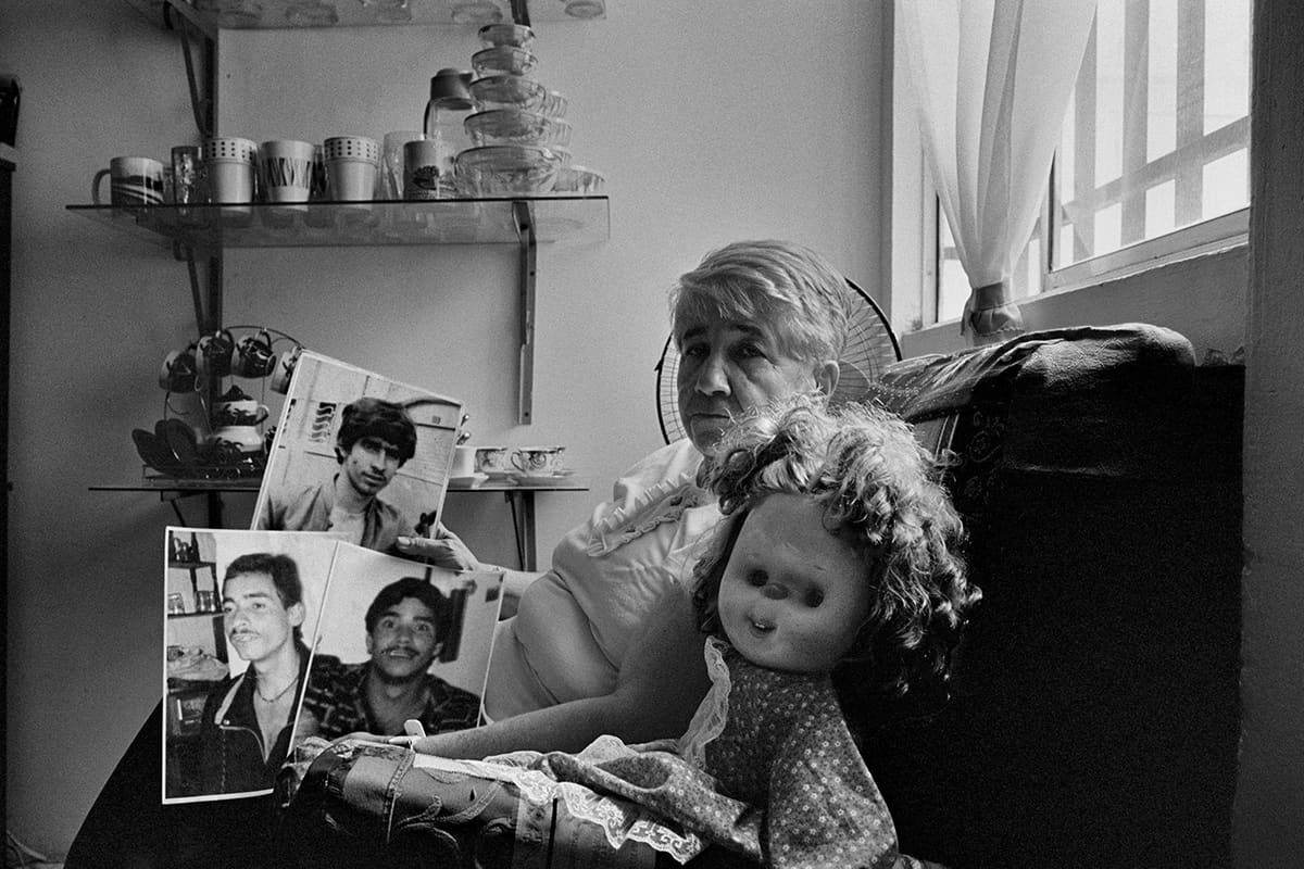 Mother holds the photographs of her two sons, one missing and one murdered, in eastern Antioquia, 2015