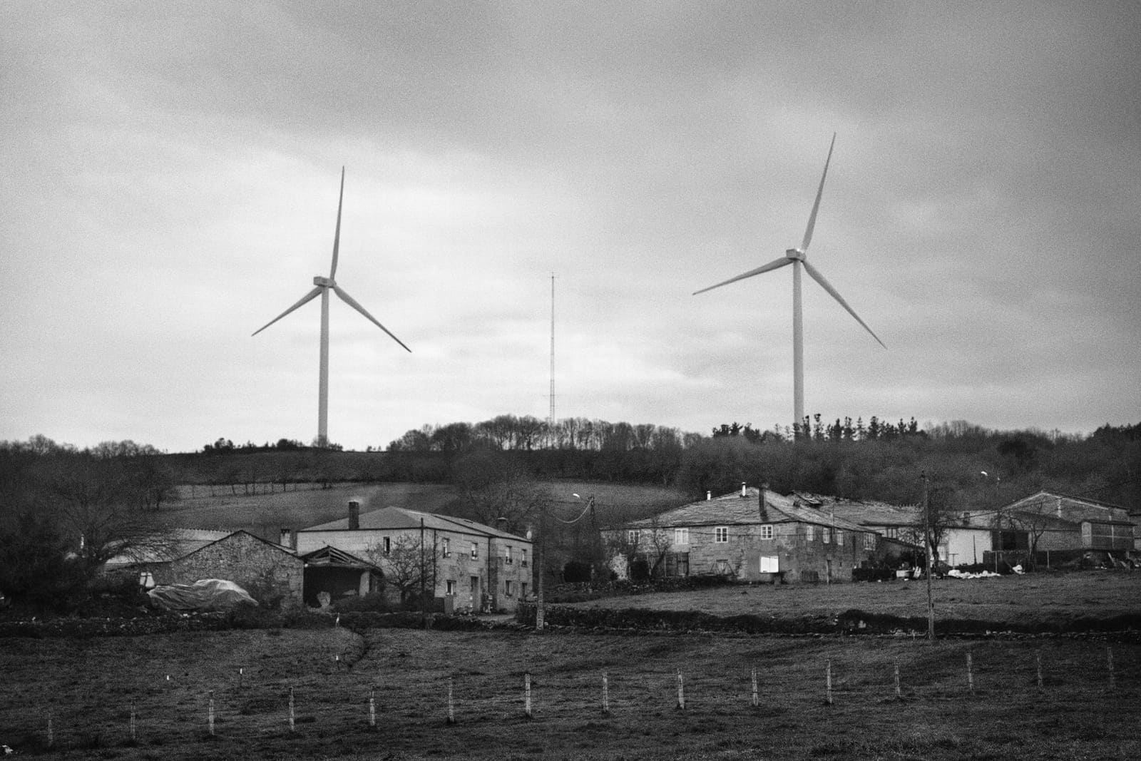 Wind turbines rising above meadows and farmland in Paradela, Galicia, Spain, 2022