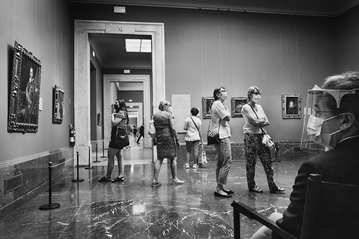 Visitors wearing face masks walking through a gallery of the Prado Museum in Madrid after its reopening during the pandemic.