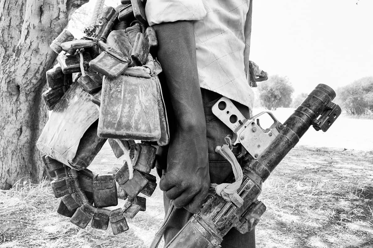 Rebel fighter carrying a machine gun and ammunition belts in Darfur, Sudan.