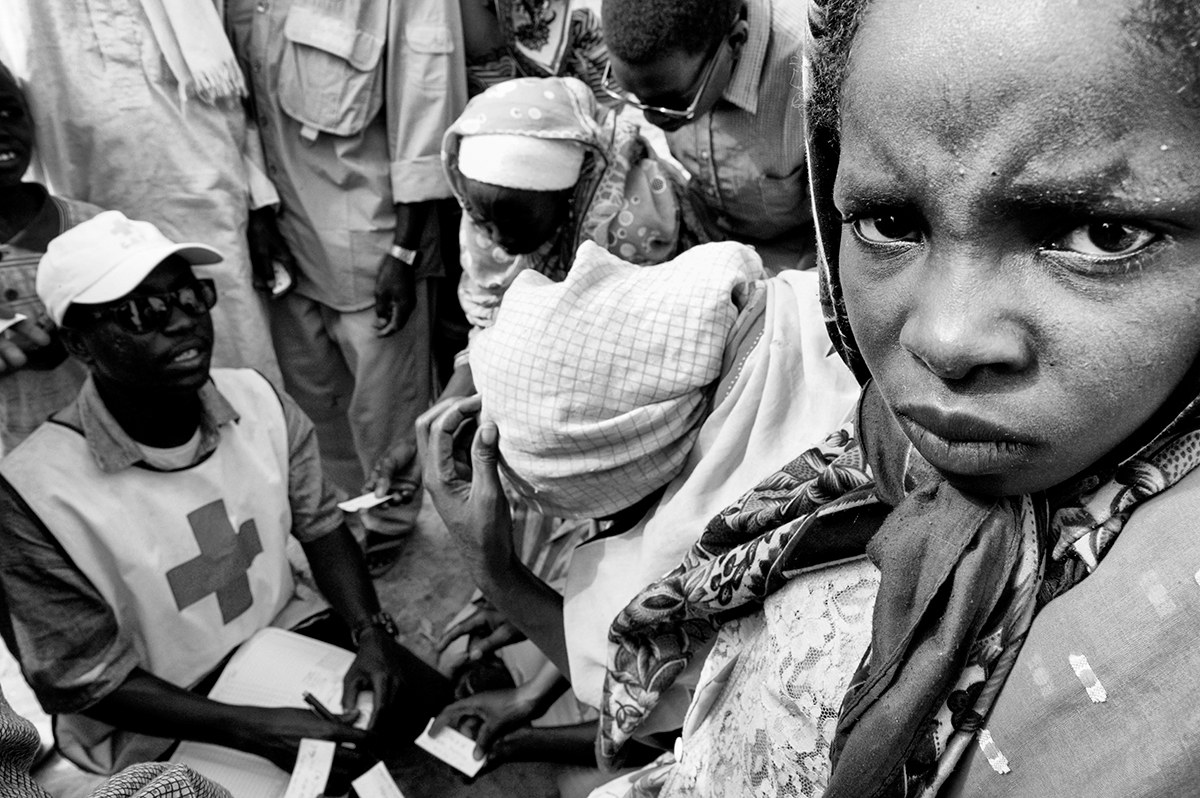 Red Cross worker registering displaced women and children at an aid distribution in Darfur, Sudan.