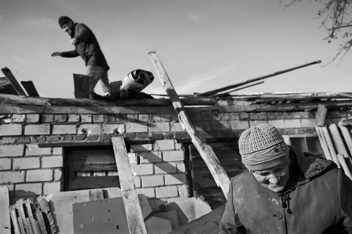 Igor and his wife Alisa look over the remains of their destroyed house in Dementiivka.