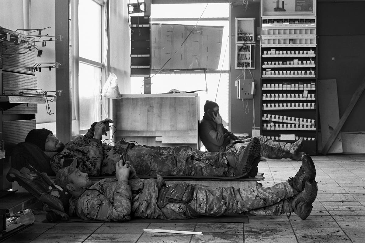Soldiers rest in a safe location near the front while waiting for the rotation back to the line.