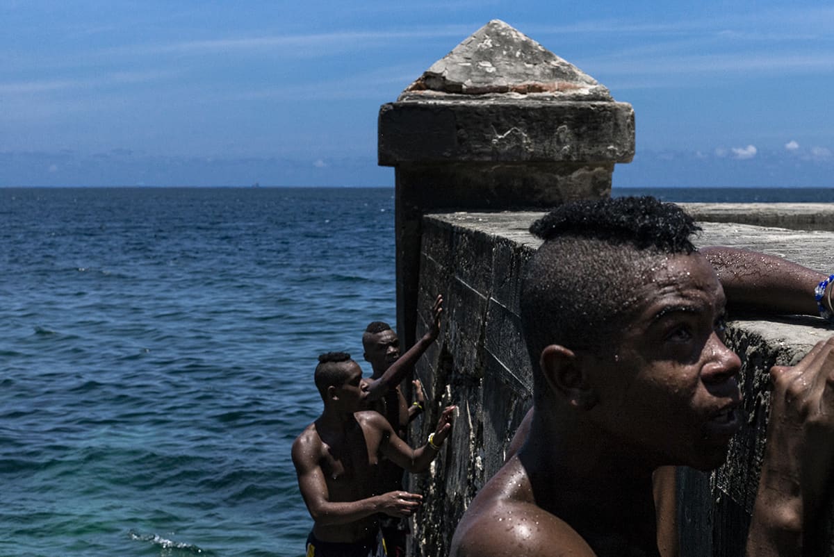Teenagers bathing in the sea beside the seawall in Centro Habana, Cuba.