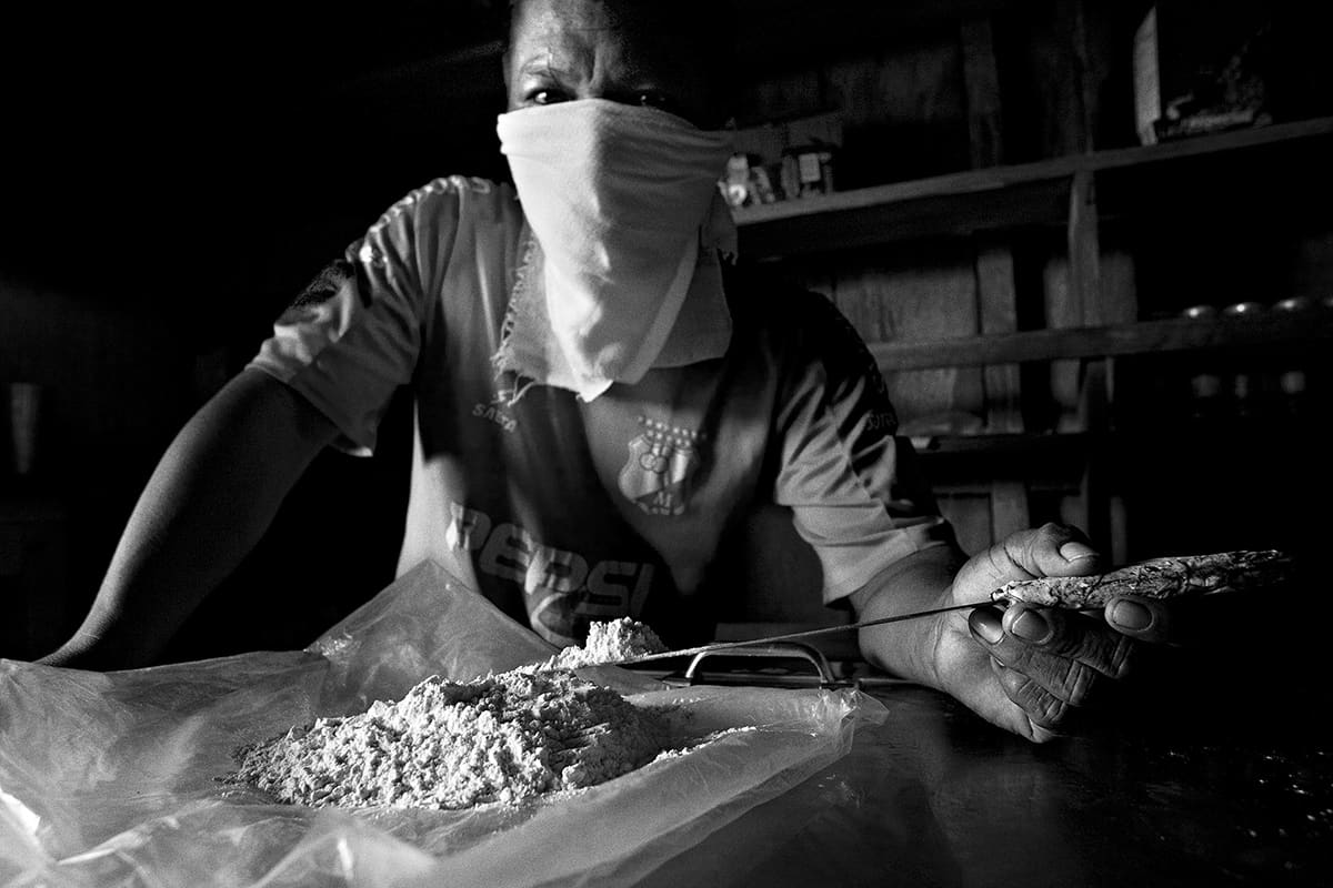 Local trafficker shows a brick of pressed cocaine ready for export from Colombia, 2007