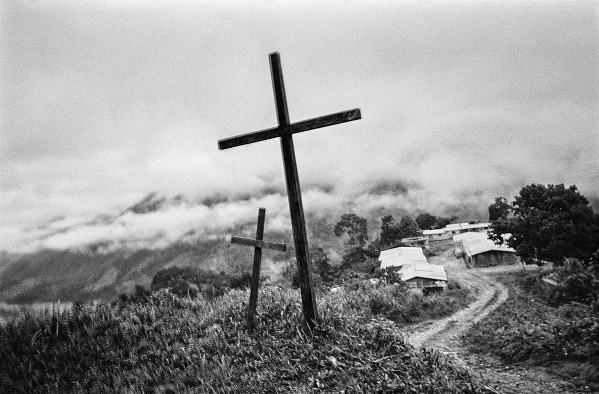 Two crosses by a rural road in Nariño marking deaths during disputes between paramilitary successor groups, 2009